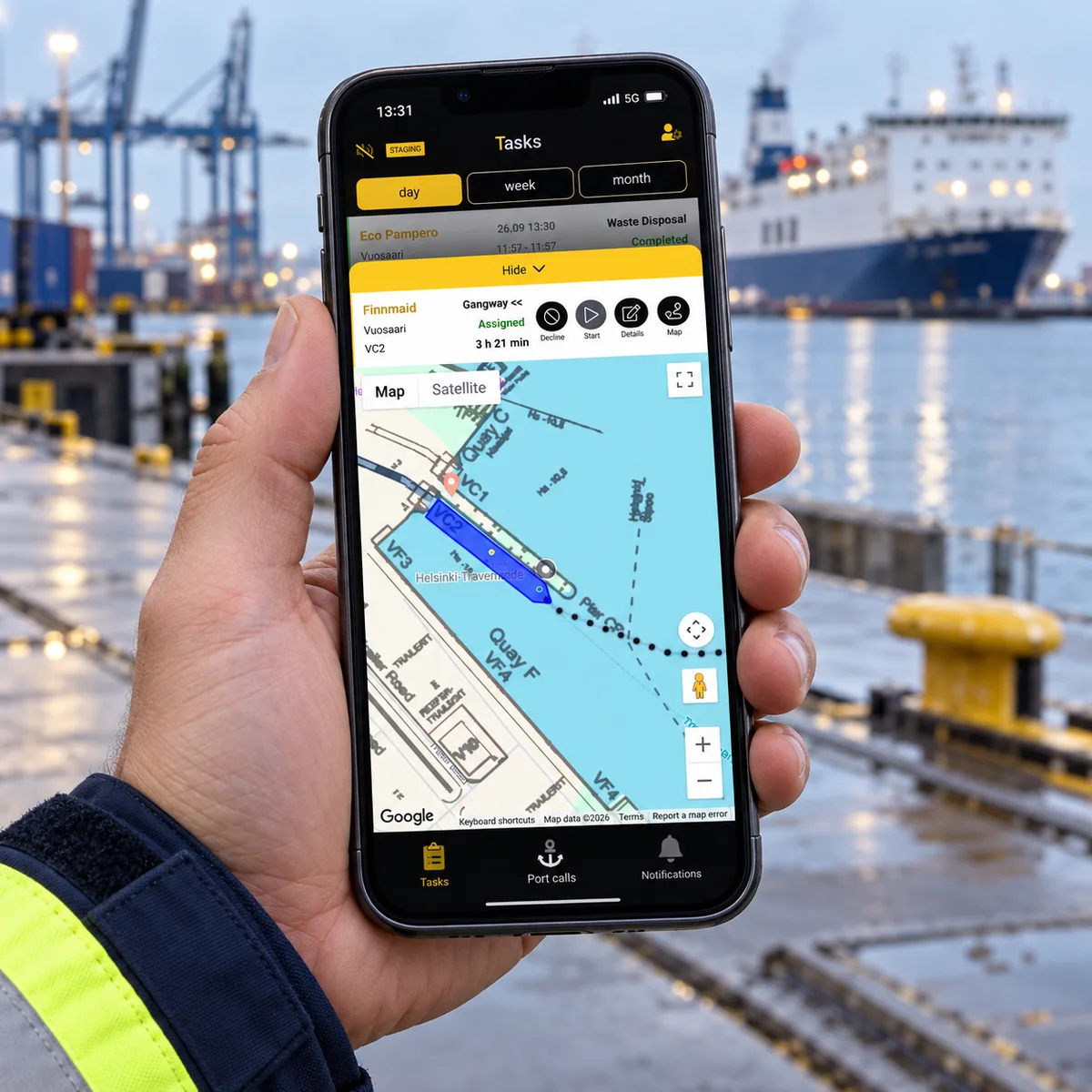 Illustrative port worker holding a phone with PortLink’s vessel and berth map.